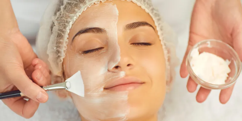 Aplicação de máscara facial hidratante em tratamento de spa, destacando a importância da hidratação intensa para revitalizar e melhorar a textura da pele em uma rotina anti-idade.