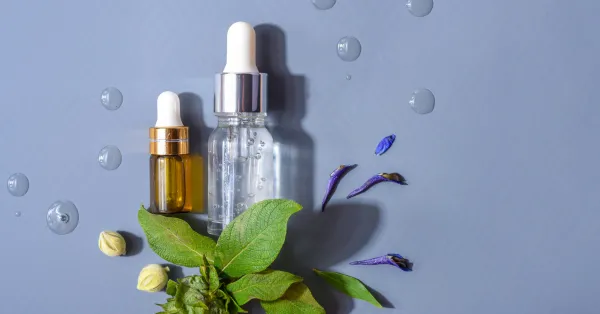 Frascos de serum de rosa mosqueta com folhas e gotas, representando os ingredientes naturais e a pureza do produto para o skincare.